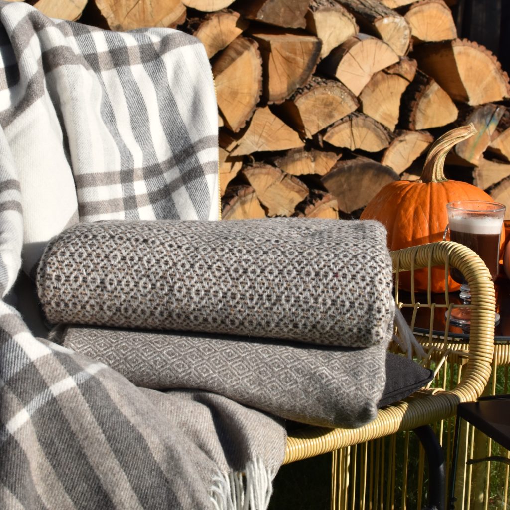 Koce z merynosa na tle drewna